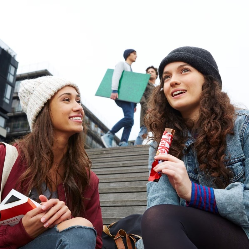 Two Woman sharing KitKat Chocolate Bar